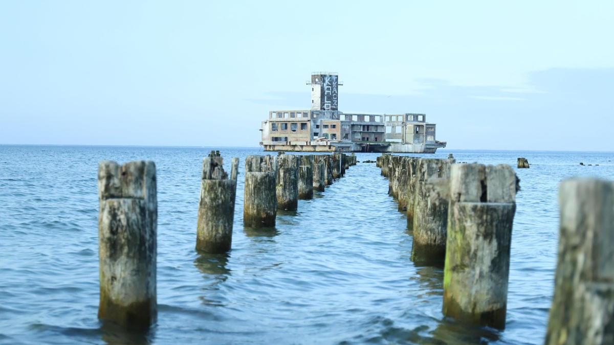 Ruiny starej Torpedowni w Gdyni Babich Dołach widoczne z piaszczystej plaży na tle Morza Bałtyckiego.