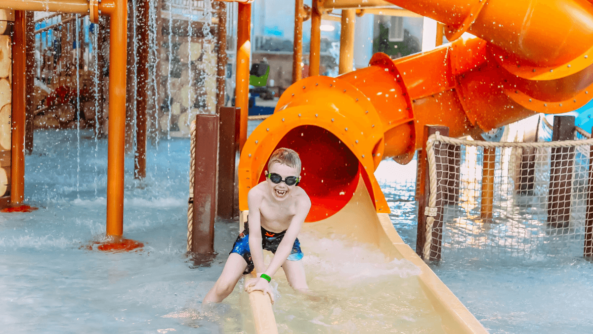 Chłopiec zjeżdżający ze zjeżdżalni wodnej
